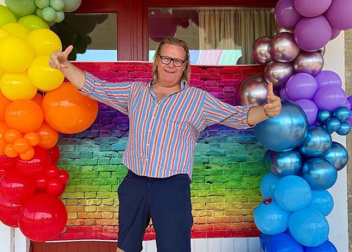 Peppe med ballonger i regnbågens färger.